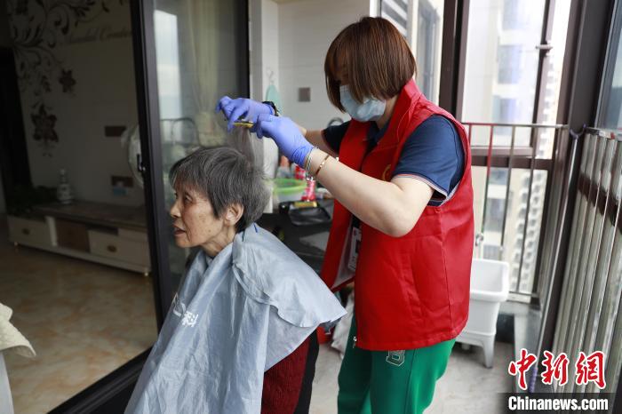 照料中心工作人员上门为老人修剪头发。　黄玲玲 供图