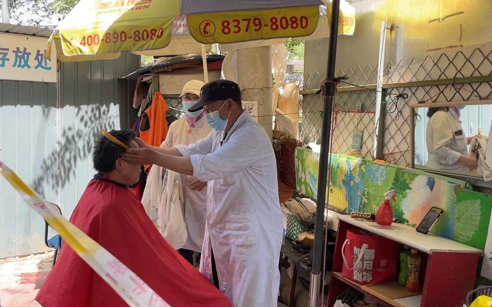 ▲梁子在给附近居民理发。新京报记者 耿子叶 摄